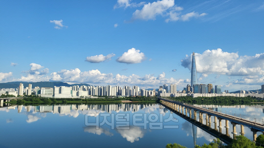 부처님 오신날 황금연휴. 지리하게 내린 빗줄기 만큼이나 아쉬움이 컸다. 한꺼번에 보상하려 했던 것일까. 대체공휴일이자 연휴 마지막날인 29일, 자연은 파아란 하늘을 선물했다. 시리도록 파란 하늘에 자칫 눈을 다칠까 걱정한 때문일까.  희디 흰 구름꽃 몇 송이도 살포시 올려놓았다. 한강은 그 하늘을, 그리고 인간의 탐욕마저  온몸으로 감싸안았다.  서울 광진구 구의동 테크노마트 하늘정원. 강건너 롯데타워와 잠실 아파트 단지, 그리고 한강을 남북으로 잇는 잠실철교의 모습을 휴대전화 카메라에 담았다.           독자 김용진 씨 제공